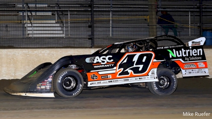 A Super Late Model rolls out of the corner under the lights